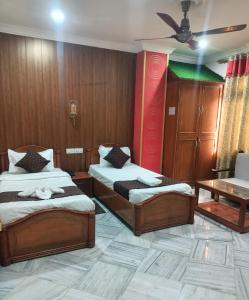 um quarto com duas camas e uma mesa em HOTEL RIZ VARANASI em Varanasi