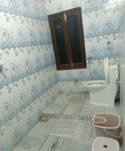 a bathroom with a toilet and blue and white wallpaper at HOTEL RIZ VARANASI in Varanasi