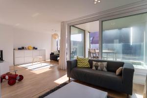 een woonkamer met een bank en een groot raam bij Lichtrijk & ruim app aan zee met zonneterras - 6p in Wenduine