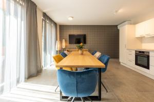 ein Esszimmer mit einem Tisch und blauen Stühlen in der Unterkunft Design Apartments Potsdam - Luise in Potsdam