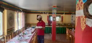 a man holding a plate in front of a table at Saser Camp in Nubra