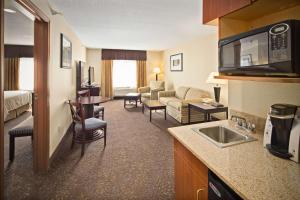 a hotel room with a kitchen and a living room at AmericInn by Wyndham Hill City Mt Rushmore in Hill City