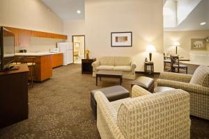 a living room with couches and a kitchen at AmericInn by Wyndham Hill City Mt Rushmore in Hill City