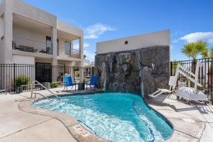 a swimming pool with a rock wall next to a house at Get Away at the Lofts #24 townhouse in St. George