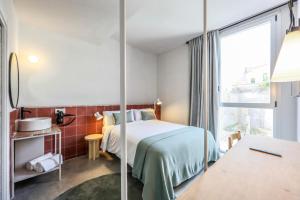 um quarto de hotel com uma cama e uma janela em Madrid Live Coworking - SELF SERVICE - em Madri