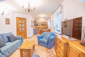 a living room with two blue chairs and a tv at Apartamenty Kazimierz Dolny in Kazimierz Dolny