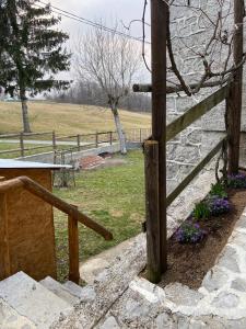 Forgaria nel Friuli的住宿－Albergo Diffuso Forgaria Monte Prat，石墙旁的木栅栏
