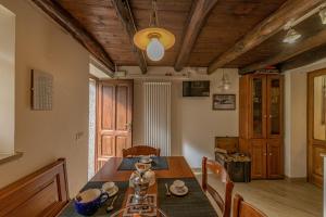 Forgaria nel Friuli的住宿－Albergo Diffuso Forgaria Monte Prat，一间带木桌的用餐室和一间餐厅