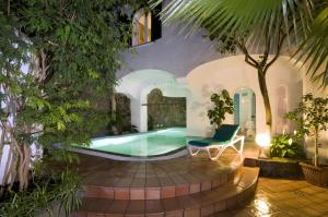 a swimming pool in the middle of a yard with trees at Hotel Villa Angelica in Ischia +37 photos