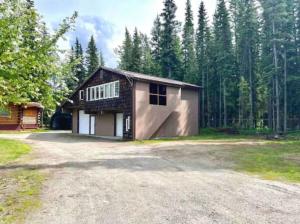 duży dom z podjazdem przed lasem w obiekcie Northern Dream Estates w mieście Fairbanks