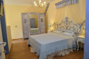 a bedroom with a blue bed and a mirror at Lavanda e Rosmarino in Sandigliano