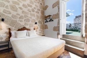 um quarto com uma cama e uma parede de pedra em Apto Azahara - Casa San Marcial em Las Palmas de Gran Canaria