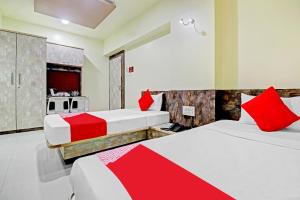 two beds in a room with red and white at Happy Homely Stay Near Pune Airport in Khadki
