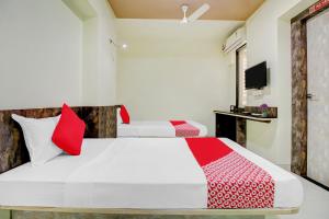 a bedroom with two beds with red and white pillows at Happy Homely Stay Near Pune Airport in Khadki