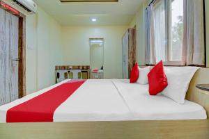 a bedroom with a large bed with red pillows at Happy Homely Stay Near Pune Airport in Khadki