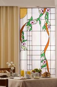 a table with a plate of food and a stained glass window at Hotel Villa Angelica in Ischia