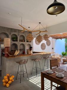 a man in a kitchen with a counter and chairs at Simply Peace in Tangalle