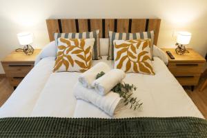 a white bed with two towels and pillows on it at Apartamento Larrazu Agroturismo Baztán in Arráyoz