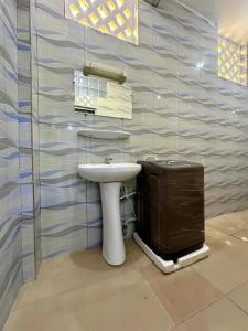a bathroom with a sink and a trash can at Luxe club des rois in Cotonou