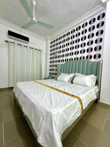 a bedroom with a large bed with a blue headboard at Luxe club des rois in Cotonou