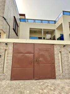 a large brown garage door in front of a house at Luxe club des rois in Cotonou