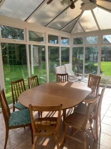 a dining room with a wooden table and chairs at La Follette in Beuzeville