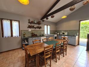 a large kitchen with a wooden table and chairs at Maison paisible avec jardin clos, terrasse, proche lac d'Eguzon et villages médiévaux - FR-1-591-102 in Vigoux