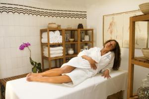 a woman in a towel sitting on a table at Hotel Villa Angelica in Ischia