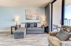 een woonkamer met een bank en een tafel en stoelen bij 0809 Carolina Shores by Atlantic Towers in Carolina Beach