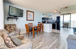 een woonkamer met een bank en een tafel en een keuken bij 0809 Carolina Shores by Atlantic Towers in Carolina Beach