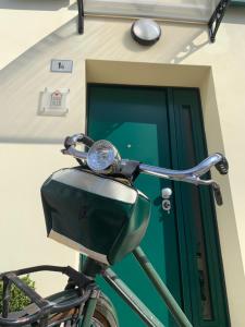 een fiets geparkeerd voor een gebouw met een groene deur bij angolo del cuore, relax e stile, app. indipendente in Casa Calari