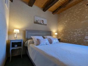 una camera da letto con un letto grande con cuscini blu di Maison de campagne avec jardin près d'Abbaye de Fontgombault et station thermale La Roche-Posay - FR-1-591-110 a Pouligny-Saint-Pierre