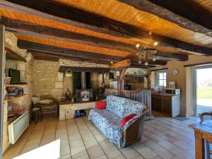 un soggiorno con divano e cucina di Maison de campagne avec jardin près d'Abbaye de Fontgombault et station thermale La Roche-Posay - FR-1-591-110 a Pouligny-Saint-Pierre