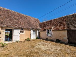 una vecchia casa con due porte bianche per il garage di Maison de campagne avec jardin près d'Abbaye de Fontgombault et station thermale La Roche-Posay - FR-1-591-110 a Pouligny-Saint-Pierre
