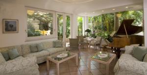 a living room with a couch and a piano at Hotel Villa Angelica in Ischia
