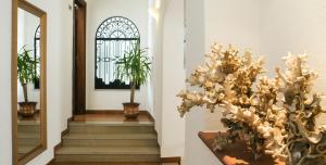 a staircase with a mirror and a plant on the wall at Hotel Villa Angelica in Ischia