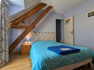 Schlafzimmer mit einem Bett mit blauer Decke in der Unterkunft Gîte Mauvières, 7 pièces, 14 personnes - FR-1-591-200 in Mauvières