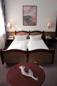 a bedroom with a bed and a table with a cake on it at Hotel Kipping in Dresden