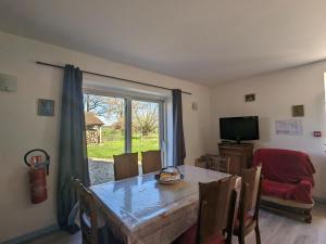 una sala da pranzo con tavolo e finestra di Charmant gîte rénové en Berry avec grand terrain, cheminée, et proximité UNESCO et thermes - FR-1-591-212 a Mauvières