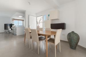 a dining room with a wooden table and chairs at Chalet con piscina en Tabaiba by Alterhome in Santa Cruz de Tenerife