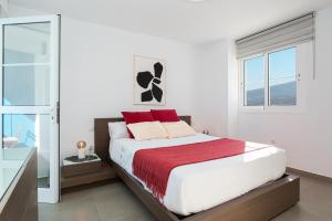 1 dormitorio con 1 cama grande con almohadas rojas en Chalet con piscina en Tabaiba by Alterhome, en Santa Cruz de Tenerife