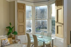 a dining room with a table and chairs and a window at Gorgeous Apartment Seconds from Seafront Clevedon in Clevedon