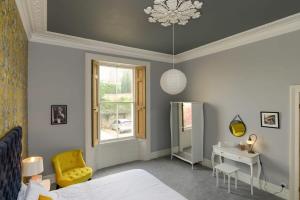 Gorgeous Apartment Seconds from Seafront Clevedon في كليفدون: غرفة نوم بسرير ومكتب ونافذة