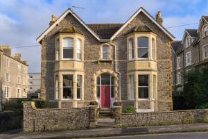 una casa de ladrillo con puerta roja en Gorgeous Apartment Seconds from Seafront Clevedon, en Clevedon