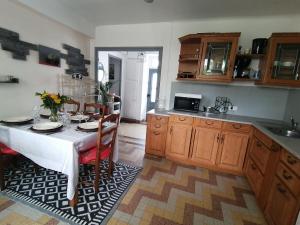 a kitchen with a table with chairs and a kitchen with a tableablish at Maison avec jardin, Spa privatif à proximité de Beauval et Valençay - FR-1-591-345 in Val-Fouzon