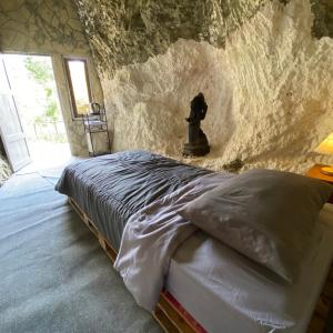 a bed in a room with a stone wall at PALEO Stone Age in Karangwetan