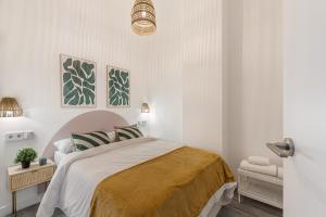 a white bedroom with a bed with a yellow blanket at BNBHolder Inspiring Salamanca in Madrid