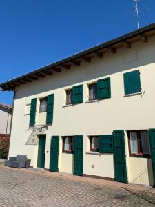 een wit gebouw met groene luiken erop bij angolo del cuore, relax e stile, app. indipendente in Casa Calari