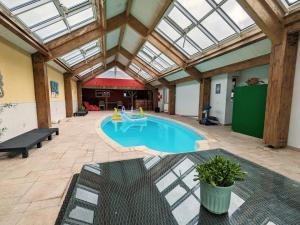 una piscina en un edificio con techo de cristal en Gîte Niherne, 7 pièces, 12 personnes - FR-1-591-427, en Niherne