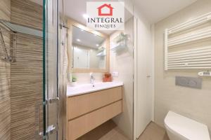 Un baño con lavabo, inodoro y espejo. en AquaVista Apartament Palamós, en Palamós 14 fotos más